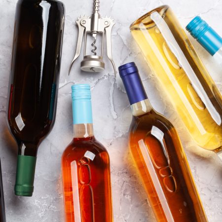 Various wine bottles and corkscrews on stone table. Flat lay